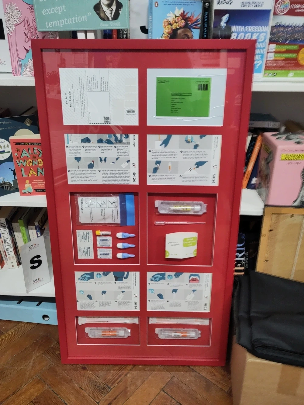 A free home STI test kit from the HSE in a large frame with each part of the test kit in its own section.