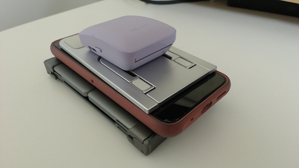 Everything from the previous image folded away and stacked on each other. They keyboard is about the same size as the phone when folded up.