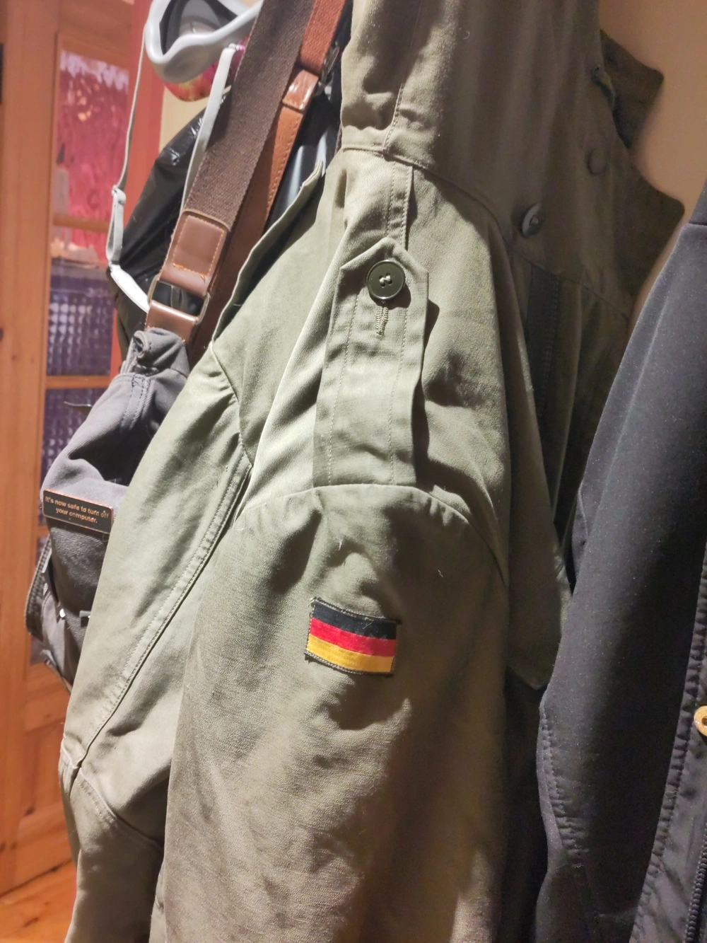 The coat hanging on a hook. It’s olive green with a German flag patch on the shoulder.