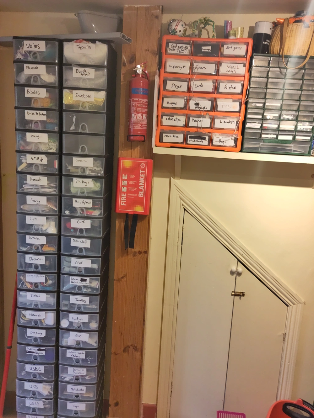 A stack of labelled plastic drawers containing everything from USB cables to bubble wrap that stretch from the floor to the ceiling.